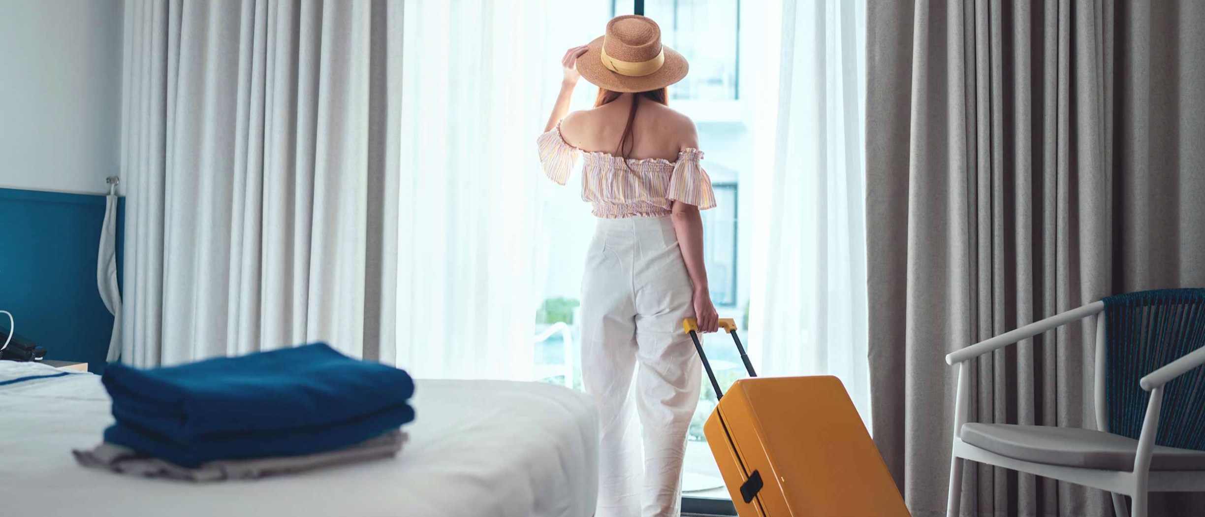 Naine seisab reisikohvriga Rootsis hotellitoas